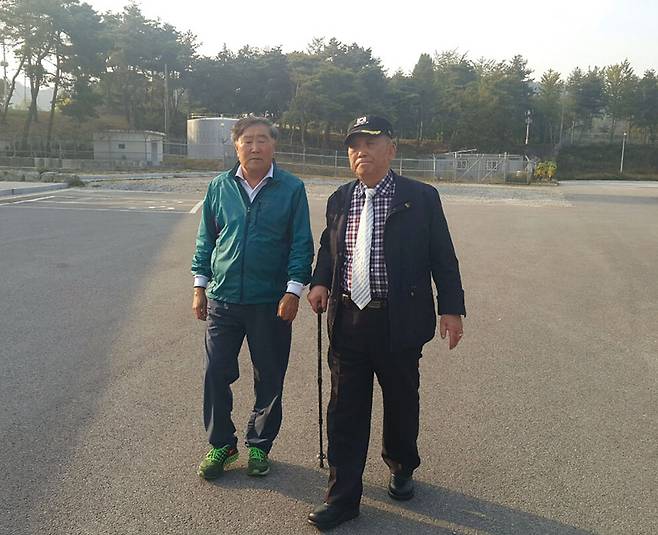 박영섭 유족회장(왼쪽)과 송영인 국민협의회 대표가 국군교도소 소장 등을 만난 후 7군단 위병소 앞을 걸어나가고 있다. © 정락인 제공