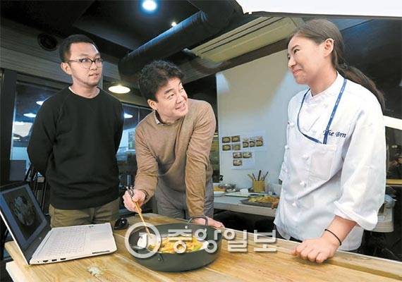 더본코리아 본사에는 조리연구실과 음식 촬영 스튜디오가 갖춰져 있다. 20일 본사 직원들과 신메뉴를 맛보며 대화하는 백종원 대표. [사진 김성룡 기자]
