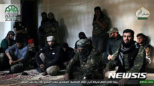 【AP/뉴시스】 10월 30일 (현지시간) 시리아 알레포 전투에 참가하기 위해 원정을 온 무장단체 아라르 알샴의 전사들이 지도자인 모하나드 알 마스리(가운데)와 함께 앉아있다. 유엔 안보리는  31일 시리아내 화학무기 사용 조사단의 활동을 연장하는 결의안을 통과시켰다.  2016.11.01