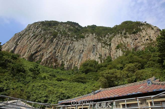 정면에서도 산방산은 다르게 보인다. 산방산 남쪽 자락에 들어앉은 광명사 경내에서 바라본 산방산은 거대한 절벽 덩어리다.