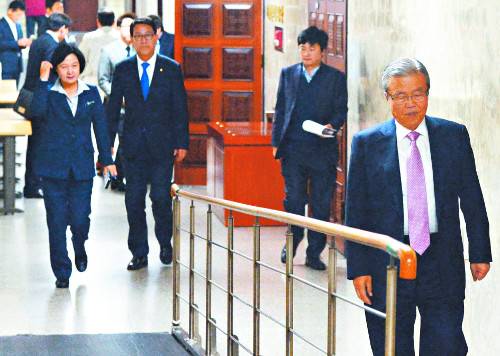 김종인 더불어민주당 전 비상대책위원회 대표(오른쪽)가 3일 국회에서 열린 민주당 긴급 의원총회 도중 착잡한 표정으로 걸어 나오고 있다. 의총에서는 청와대에 대한 강경 대응 목소리가 분출했다. 왼쪽은 추미애 민주당 대표. 뉴시스