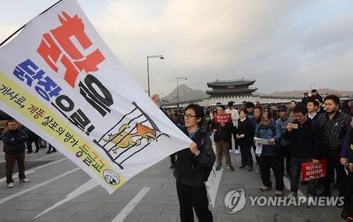 화난민심      (서울=연합뉴스) 한상균 기자 = 박근혜 퇴진 촉구 3차 촛불집회가 열린 12일 오후 서울 광화문 광장에서 한 시민이 퇴진촉구 깃발을 들고 있다.