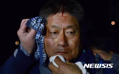 【서울=뉴시스】김선웅 기자 = 26일 오전 서울 서초구 경부고속도로 양재IC 인근 도로에서 제5차 촛불집회 참석을 위해 상경하던 농민들이 경찰과 대치, 한 농민이 부상을 입고 피를 흘리고 있다. 2016.11.26.   mangusta@newsis.com