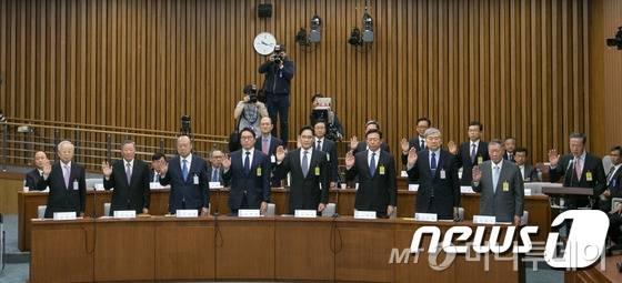 이재용 삼성전자 부회장(가운데)이 6일 오전 서울 여의도 국회에서 열린 박근혜 정부의 최순실 등 민간인에 의한 국정농단 의혹사건 진상규명을 위한 국정조사에서 물을 마시고 있다./사진공동취재단