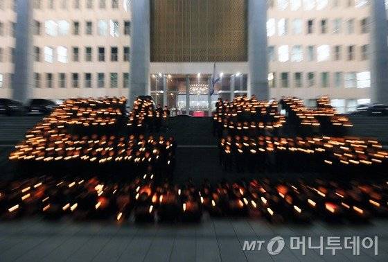 더불어민주당 추미애 대표와 우상호 원내대표를 비롯한 의원들과 당직자들이 5일 서울 여의도 국회 본청 앞에서 열린 박근혜 대통령 탄핵 촉구 촛불집회에서 촛불을 들고 '탄핵' 글자를 밝히고 있다. 2016.12.5/뉴스1  <저작권자 © 뉴스1코리아, 무단전재 및 재배포 금지>