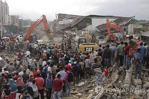 '잔해 속 사람들 다치지 않게…'        (피디에 자야<인도네시아> AP=연합뉴스) 인도네시아 서부 아체주 해안에서 7일 오전(현지시간) 발생한 규모 6.5의 강진으로 8일 오전 현재 99명이 숨지고 136명이 중상인 것으로 집계됐다.       사진은 피디에 지야에서 7일 건물 잔해 속에 묻힌 피해자 구조에 포크레인이 동원된 모습.