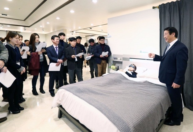김경수 에몬스가구 회장(맨 오른쪽)이 대리점주를 상대로 심박수, 호흡수, 뒤척임 등 수면 패턴을 실시간으로 분석해 알려주는 ‘스마트 침대’에 대해 설명하고 있다. 에몬스가구 제공
