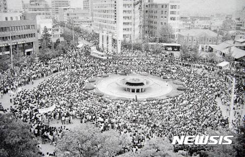 【광주=뉴시스】신대희 기자 = 5·18민주화운동 상징 공간인 광주 전일빌딩의 총탄 흔적이 헬기에서 쏜 것으로 보인다고 분석한 국립과학수사연구원이 14일 "옛 전남도청 쪽에서 금남로 방향으로 돌면서 사격한 것으로 추정된다"고 밝혔다. 사진은 1980년 5·18 당시 광주 동구 금남로 전일빌딩 주변 모습. (사진 = 5·18 기념재단 제공 사진 촬영)    photo@newsis.com