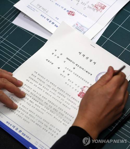 박 대통령, 탄핵 심판 답변서 제출      (서울=연합뉴스) 한종찬 기자 = 이중환 변호사를 비롯한 탄핵심판 대통령 법률 대리인단이 16일 오후 서울 종로구 헌법재판소 민원실에 헌법재판소에 국회의 탄핵 사유에 대한 반박 입장을 담은 답변서, 이의신청서와 변호사 선임신고서를 제출했다. 사진은 이날 제출한 이의신청서.  saba@yna.co.kr