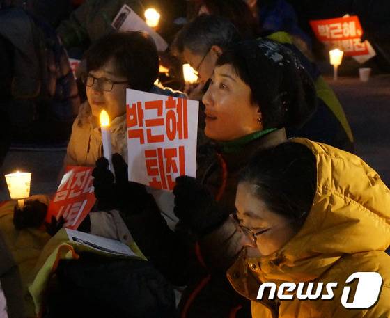 24일 오후 춘천시민들이 강원 춘천시 석사동 김진태 국회의원 사무실 앞에서 열린 ‘박근혜 퇴진 춘천시국대회’에 참여해 촛불집회를 하고 있다. 2016.12.24/뉴스1 © News1 박태순 기자