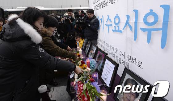 12월28일 서울 종로구 구 일본대사관 앞에서 열린 제1263차 일본군 '위안부' 문제해결을 위한 정기 수요시위에서 참가자들이 돌아가신 할머니들 영정 앞에 헌화하고 있다. /뉴스1 © News1 안은나 기자