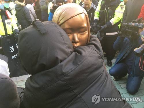 '울지마…' 소녀상 부둥켜 안은 시민        (부산=연합뉴스) 김선호 기자 = 28일 오후 부산 동구 초량동 일본영사관 앞 인도에서 '평화의 소녀상' 설치를 시도하며 연좌농성을 벌이던 '미래세대가 세우는 평화의 소녀상 추진위원회' 소속 회원이 관할구청인 동구청 직원들이 끌어내려고 시도하자 소녀상을 부둥켜 안고 있다.2016.12.28      wink@yna.co.kr