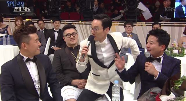 이휘재(오른쪽 두 번째)가 지난 연말 열린 ‘KBS 연예대상’에서 대상 후보인 김종민과 김준호를 인터뷰하던 중 데프콘(오른쪽 세 번째)의 무릎에 앉아 질문해 논란이 됐다. KBS 방송화면 캡처