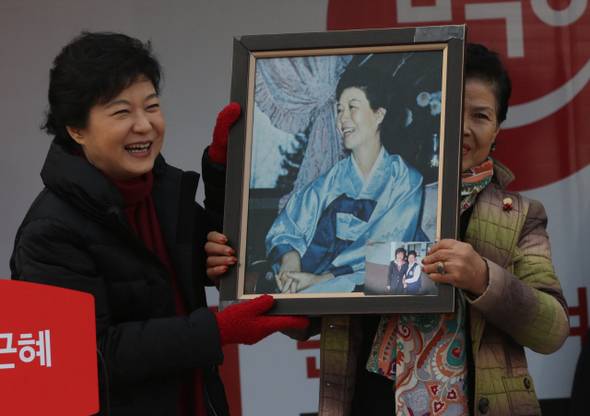 박근혜 새누리당 대통령 후보가 2012년 11월28일 오전 충남 홍성군 오관리 하상복개 주차장에서 열린 유세에서 한 지지자가 가져온 박 후보의 어머니 육영수씨의 사진을 함께 들어보이고 있다.  홍성/강창광 기자 chang@hani.co.kr