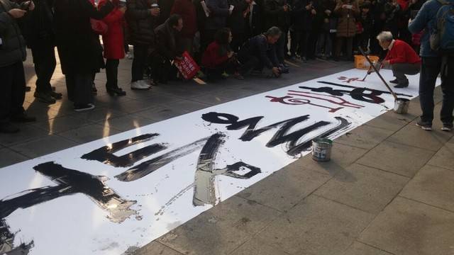 7일 서울 광화문광장에서 고암 정병례 작가가 흰 현수막에 ‘어둠을 홰쳐’라는 붓글씨를 쓰고 있다. 고한솔 기자