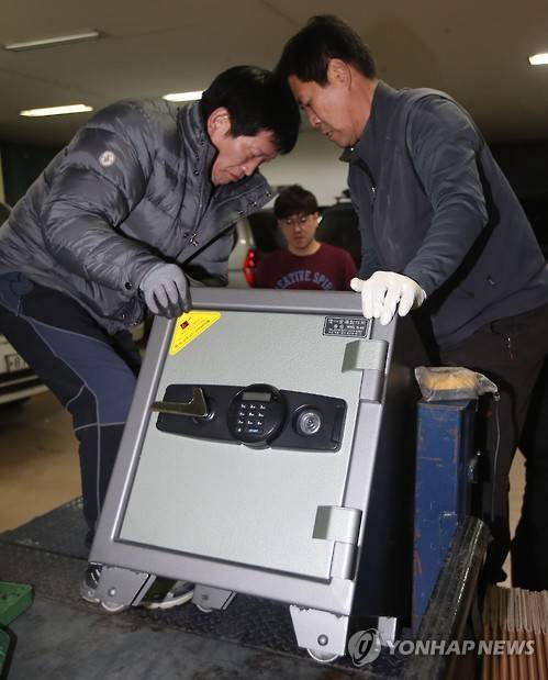 2016년 12월 11일 '최순실 국정농단 의혹' 특검 사무실이 마련된 서울 강남구의 한 건물에서 이사업체 관계자들이 법무법인 강남 사무실에서 가져온 금고를 특검 사무실로 옮기고 있다.[연합뉴스 자료사진]