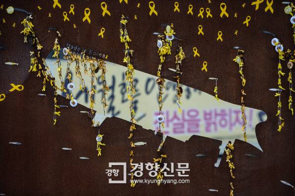 세월호 참사의 아픔을 고스란히 간직하고 있는 전남 진도 팽목항에 설치된 세월호를 본뜬 모형 배 너머로 희생자 합동분향소가 보이고 있다.  진도 팽목항 | 이준헌 기자 ifwedont@kyunghyang.com