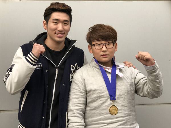 팬 선다훈 군과 함께 주먹을 불끈 쥐고 포즈를 취한 박상영 선수.(사진제공=노블스포츠뉴스)