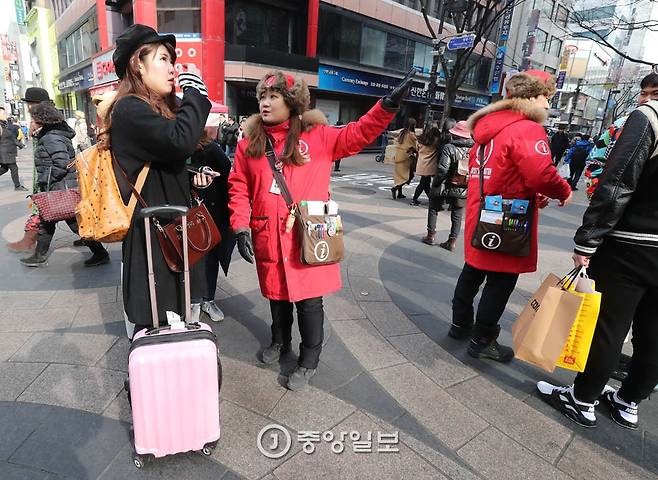 여행가방을 끌고 온 일본 관광객에게 길안내를 하고 있다. 신인섭 기자