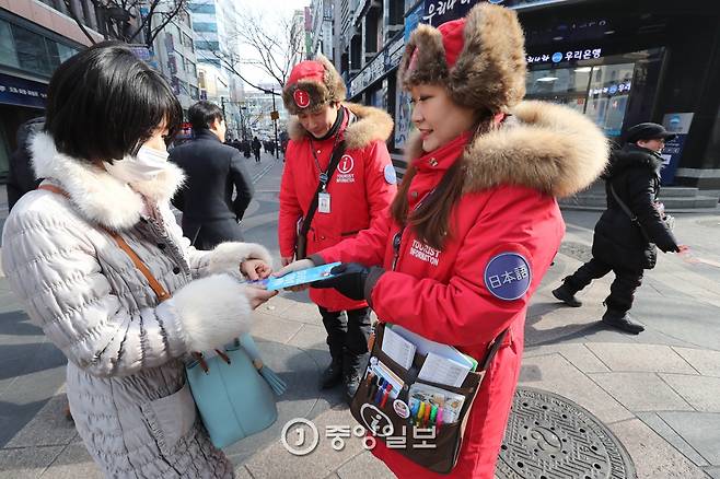 관광객에게 명동 일대 지도를 주고 있다. 신인섭 기자