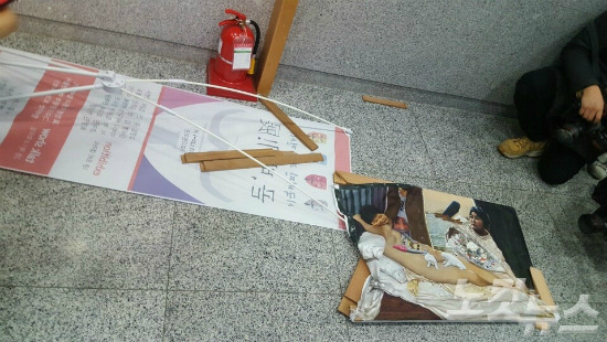 보수단체 회원으로 추정되는 시민들이 24일 국회 의원회관에 전시된 박근혜 대통령 누드 풍자화를 훼손했다. (사진=김수영 기자)