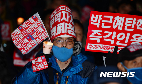【광주=뉴시스】배동민 기자 = 박근혜 퇴진 광주시민운동본부는 25일 오후 광주 동구 금남로에서 '박근혜 퇴진 17차 광주 시국 촛불대회'를 열었다. 한 참가자가 '박근혜 즉각 탄핵'을 외치며 촛불을 밝히고 있다. 2017.02.25.   guggy@newsis.com