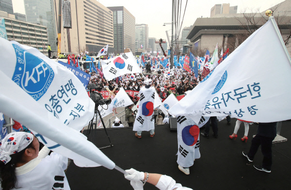 3월 1일 자유총연맹 회원들이 서울 세종로공원에서 깃발을 흔들고 있다. / 연합뉴스
