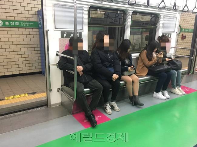 지난 2015년 서울시가 지하철의 임산부 배려석이 눈에 쉽게 띄도록 좌석을 분홍색으로 바꿨지만 여전히 많은 임산부들이 혜택을 누리지 못한다는 지적이 나온다. 남성 승객들이 지하철 임산부 배려석에 앉아 있는 모습. 이현정 기자/rene@heraldcorp.com
