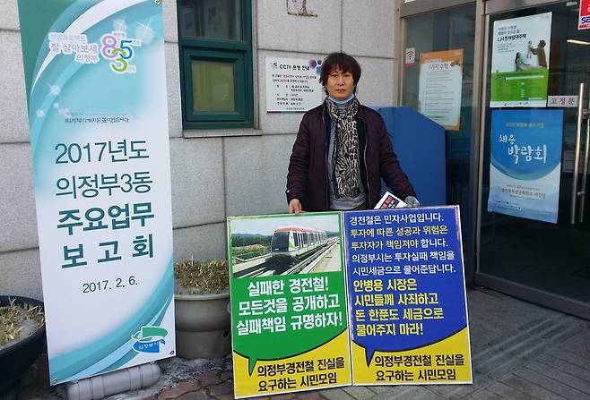 경기도 의정부지역 시민단체인 ‘의정부경전철 진실을 요구하는 시민모임’의 한 회원이 지난달 의정부3동 주민센터 앞에서 의정부경전철 실패 책임 규명을 촉구하며 1인시위를 벌이고 있다. 의정부경전철 시민모임 제공