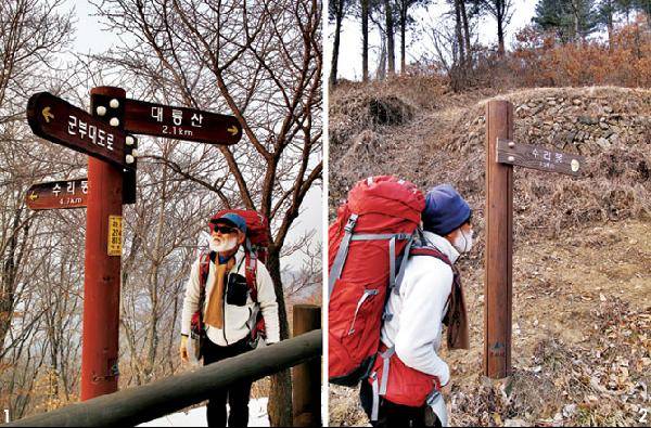 [월간산]1 새골 갈림길 오거리에서 한 시간 안팎 오르면 나오는 녹두봉 서쪽 아래 군부대 도로 옆 푯말. 뒤로 보이는 능선은 고은리 방면 865m봉 서릉이다. 2 원창4리 매내미 마을에서 수리봉 서릉으로 오르는 등산로 입구 푯말.