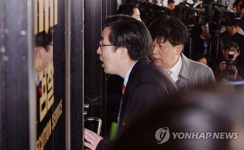 (서울 사진공동취재단=연합뉴스) 뇌물수수 등 13개 범죄혐의로 검찰에 소환된 박근혜 전 대통령 측 손범규 변호사가 21일 오전 서울중앙지검 현관 출입문에서 안쪽에 대고 이야기를 하고 있다. 2017.3.21      photo@yna.co.kr