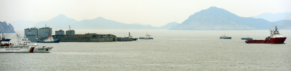 침몰 해역인 전남 진도 동거차도 앞바다에서 24일 인양된 세월호가 예인선에 이끌려 반잠수선박으로 이동하고 있다. 사진공동취재단