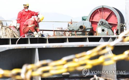 (목포=연합뉴스) 7일 오전 전남 목포신항에 접안해 있는 반잠수식 선박에서 작업자들이 세월호 육상 운송을 위해 특수이동장비인 모듈 트랜스포터(Module transporter: MT) 진입공간 확보작업을 하고 있다. 2017.4.7 [해양수산부 제공=연합뉴스]      photo@yna.co.kr