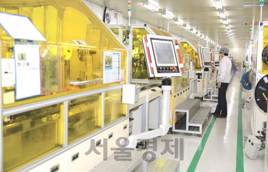 LS오토모티브 직원이 자동차 부품을 하나의 완성된 모듈로 만드는 자동화 공정작업을 살펴보고 있다. /사진제공=LS오토모티브
