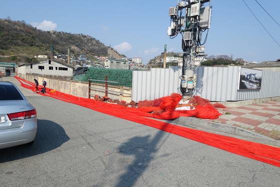 가동을 멈춘 지 꽤 오래된 조선내화 공장 담 아래서 동네 아주머니 넷이 수백m가 넘는 그물을 손질하고 있다. 산 아래 보이는 동네가 다순그미(온금동)다.