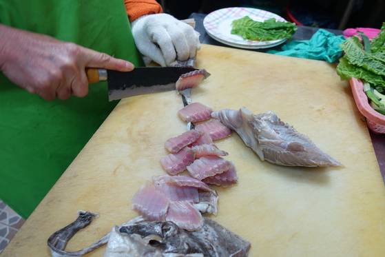 홍어 한 접시는 몸통 살과 날개·연골을 섞어서 담는다. 붉은 빛이 도는 것이 몸통 살이고 오른쪽 자르지 않은 덩어리는 날개 살이다.