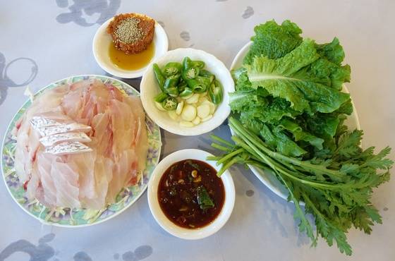 영란횟집의 민어회 한 접시. 가운데 하얀 껍질이 붙은 게 뱃살이고 분홍빛을 띤 것은 몸통 속살이다. 막걸리식초로 만든 초고추장과 쑥갓을 듬뿍 주는 것이 이 집 특색이다.