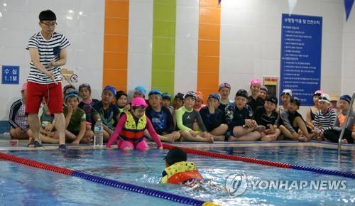 (제주=연합뉴스) 전지혜 기자 = 26일 제주시 삼성초등학교 수영장에서 진행된 외도초등학교 학생 대상 생존수영교육에서 한 교사가 줄을 묶은 페트병을 이용해 어린이를 구조하는 시범을 보이고 있다. 2017.4.26      atoz@yna.co.kr
