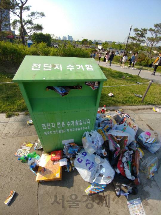 지난 29일 여의도 한강공원 입구에 비치된 전단지 수거함 양 옆으로 쓰레기와 전단지가 쌓여 흉물스럽다. /신다은 기자