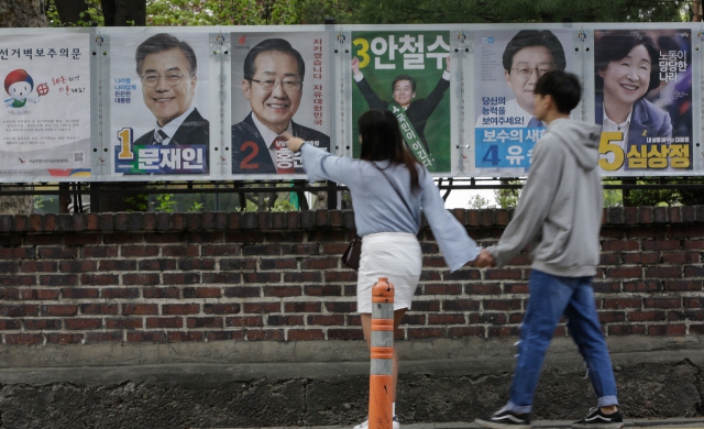 지난달 20일 제19대 대통령 선거 벽보가 걸린 서울 종로구 동숭동 거리를 지나가던 시민들이 후보들의 면면이 담긴 벽보를 둘러보고 있다. 김진수 기자 jsk@hani.co.kr