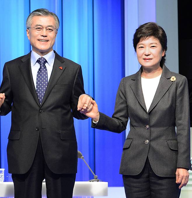 2012년 당시 민주통합당 문재인ㆍ 새누리당 박근혜 대통령 후보가 12월 4일 서울 여의도 MBC 스튜디오에서 방송토론을 하기에 앞서 손을 잡고 사진찍고 있다. 이날 토론회는 중앙선거관리위원회가 주최한 18대 대선 첫 TV토론이었다.