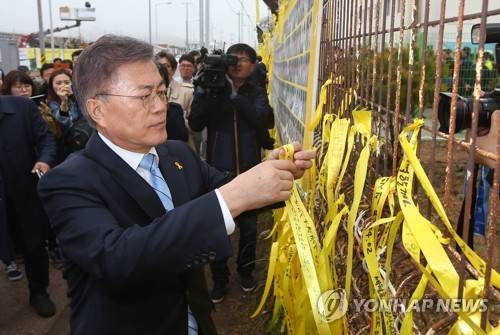 (목포=연합뉴스) 김현태 기자 = 문재인 대통령이 후보 시절인 지난달 6일 오후 전남 목포신항을 방문, 노란 리본을 매달고 있다. 2017