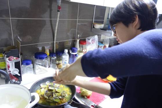 엑스트라 버진 올리브 기름에 마늘 편과 손으로 부순 페페로치노를 넣고 볶다가 미더덕 살, 삶은 바지락을 넣고 파스타 소스를 만들던 김현정 셰프가 통후추를 갈아서 넣고 있다.