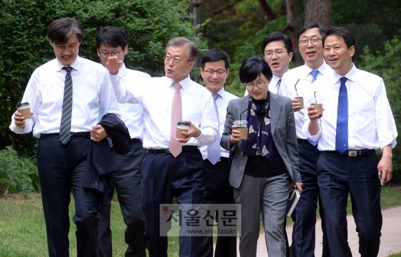 테이크아웃 커피 들고 젊은 참모진과 산책  - 문재인 대통령이 11일 오후 신임 수석비서관 등과 점심 식사 후 음료를 들고 청와대 경내를 산책하며 대화를 나누고 있다. 왼쪽부터 조국 민정수석, 권혁기 춘추관장, 문 대통령, 이정도 총무비서관, 조현옥 인사수석, 송인배 전 더불어민주당 선대위 일정총괄팀장, 윤영찬 국민소통수석, 임종석 비서실장.안주영 기자 jya@seoul.co.kr