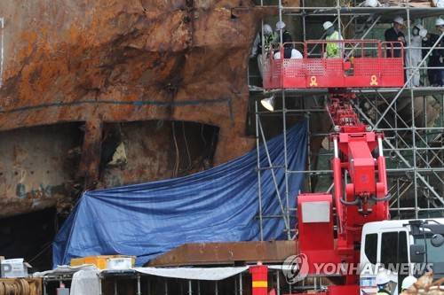 (목포=연합뉴스) 이상학 기자 = 세월호 선미부분에서 '사람 뼈'로 추정되는 뼈가 다수 발견된 12일 오후 세월호가 거치된 목포신항에서 관계자들이 뼈가 발견된 4층 선미 부분(4-11구역)에 가림막을 설치하고 관련 작업을 진행하고 있다.   2017.5.12  leesh@yna.co.kr  (끝)