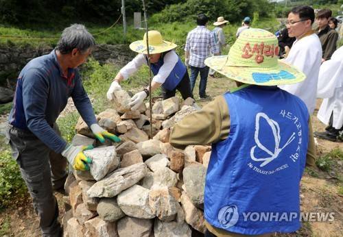 (성주=연합뉴스) 김준범 기자 = 13일 오후 사드가 배치된 경북 성주골프장 인근 진밭교 삼거리에서 열린 불법사드 원천무효 제3차 소성리 범국민 평화 행동에서 참가자들이 평화의 돌탑을 쌓기 위해 줄지어 돌을 나르고 있다. 2017.5.13