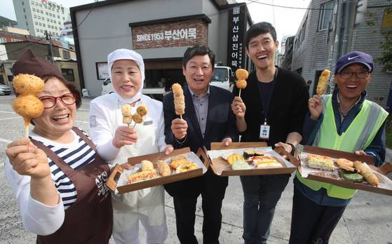 전 직원 475명이 100% 정규직인 부산 영도의 중소기업 삼진어묵 본사에서 15일 박종수 사장(가운데)이직원 이정분(청소)·허경숙(생산)·강문구(매장관리)·김상철(주차)씨와 파이팅을 외치고 있다. [송봉근 기자]