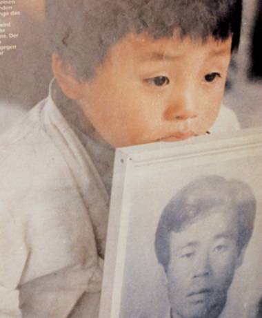 5·18 당시 독일 '슈피겔지'에 실려 광주의 아픔을 전 세계에 전했던, 아버지의 영정사진을 든 아이(사진=5·18기념재단 홈페이지 화면 갈무리)