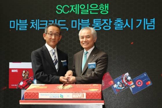 박종복 SC제일은행 은행장(오른쪽)과 토루 안도 월트디즈니 컴퍼니 코리아 대표(왼쪽)가 30일 서울 종로구 소재 SC제일은행 본점에서 열린 마블 체크카드 및 마블 통장 출시 기념행사에서 기념촬영을 하고 있다. / 사진제공=SC제일은행