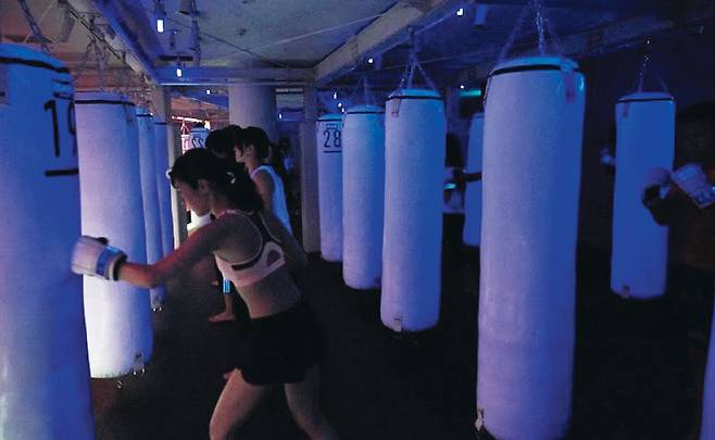 일본 도쿄에 있는 권투 연습장‘비몬스터’에서 시민들이 야간 운동에 열중하고 있다. 이 연습장은 남의 시선을 의식할 필요 없이 운동할 수 있도록 조명을 어둡게 만들어 옆 사람 얼굴을 알아보기가 어렵다. /비몬스터